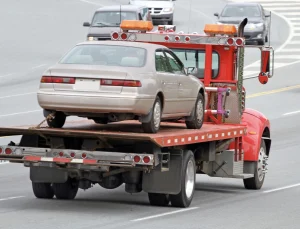flatbed tow truck with brown car